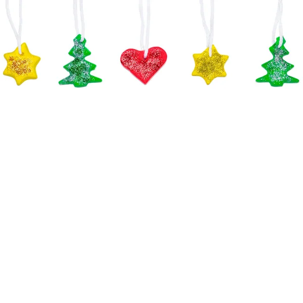 Noel ağacından çelenk, kırmızı, sarı ve yeşil plastikten yapılmış yıldız ve kalp. Fotokopi alanı olan Noel ya da Yeni Yıl afişi. Plastikçilik kavramı — Stok fotoğraf