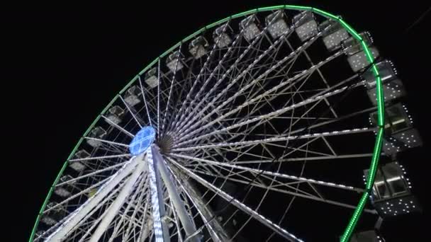 Nachtzicht op groot reuzenrad met prachtige verlichting. Winter reuzenrad draaiend in een pretpark. 4K resolutie video — Stockvideo