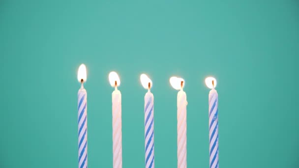 Concepto de Feliz Cumpleaños Hecho de Velas de colores ardientes sobre fondo azul o turquesa. Quemando velas de cumpleaños de cinco años. Vídeo de resolución 4K — Vídeos de Stock