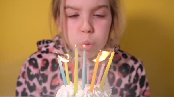 Happy teen girl in leopard Overalls blows out ten colorful candles on birthday cupcake at party. Close up on girl face. Slow motion happy birthday video banner — Stock Video
