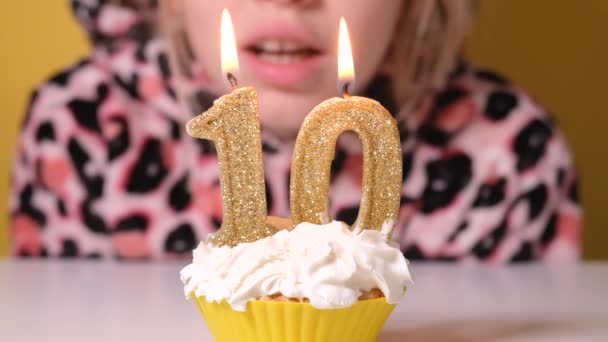 Šťastné teen dívka v leopard kombinézy sfoukne číslo 10 svíčka na narozeninovém dortu na párty. Zblízka dívčí tvář. Zpomalit film Happy birthday video banner. — Stock video
