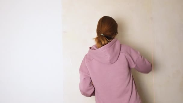 La chica cubre la pared con pegamento de papel pintado. Haga la reparación o renovación usted mismo concepto. Hágalo usted mismo reparación. Vídeo de resolución 4K — Vídeo de stock