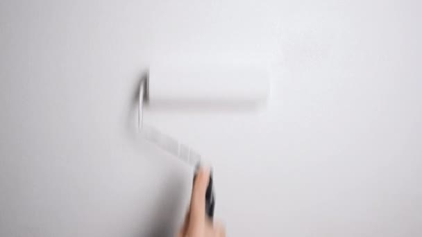 Χέρι με Roller ζωγραφική τοίχο με λευκό χρώμα. Βάφοντας έναν γυμνό τοίχο με έναν κύλινδρο μπογιάς με λευκή μπογιά. Βίντεο ανάλυσης 4K — Αρχείο Βίντεο