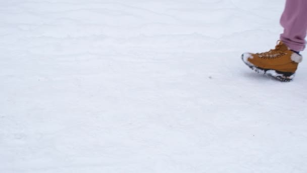 Patas femeninas corriendo sobre la nieve blanca. Actividades al aire libre de invierno. Cámara lenta full HD de vídeo — Vídeo de stock
