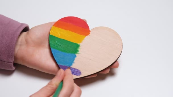 Pinta a mano un corazón de madera en colores de Gay Pride Flag. Colorido símbolo de LGBTQIA. Banner de vídeo de resolución 4K — Vídeo de stock