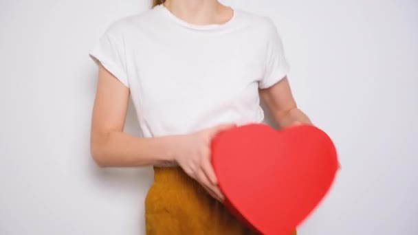 Mulher dançando e abraçando uma grande caixa vermelha em forma de coração. Banner de vídeo na moda para o Dia dos Namorados, Dia Internacional das Mulheres ou dia das mães. — Vídeo de Stock