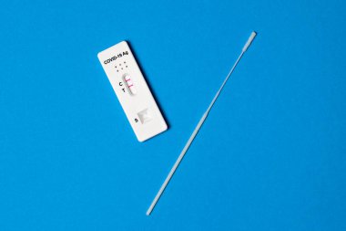 Mavi arka planda karbondioksit 19 için hızlı test cihazı kullanarak elde pozitif sonuç elde tutuyoruz. Evde Corona virüsü enfeksiyonu teşhisi