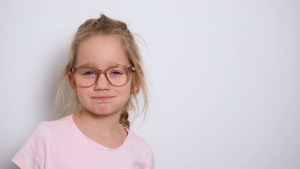 En liten flicka tittar rakt in i kameran och skrattar. Banner med kopieringsutrymme. 4k upplösning video — Stockvideo