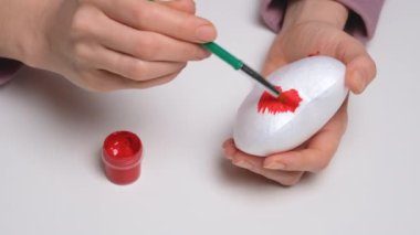 El, köpük plastik bir kalbi kırmızıya boyar. 4K çözünürlük video pankartını kapat. Sevgililer Günü için DIY konsepti, Uluslararası Kadınlar Günü veya Anneler Günü.
