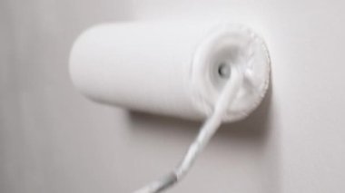 Beyaz boyalı paten boyama duvarı. Beyaz boyalı bir boya silgisiyle çıplak bir duvar boyamak. Tam HD yavaş çekim videosu