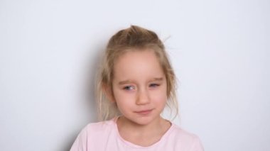 Küçük bir kız aktif olarak bir şey söylüyor ve kameraya bakıyor. Kız şarkı söyler ya da şiir okur. Video portresi. 4k çözünürlük videosu
