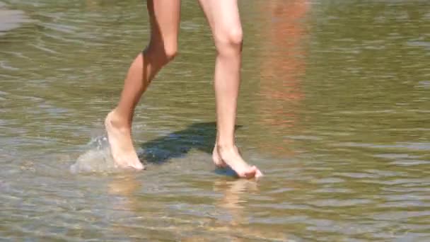 Бігаючі ноги дівчини на морському пляжі. Літній відео банер з копіювальним простором. Крупним планом молоді дівчата ноги ходять або бігають на пляжі з мілководдям. Повне HD повільне відео руху . — стокове відео