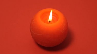 Kırmızı arka planda izole edilmiş kırmızı yanan mum. Mum yanan tam HD yavaş çözünürlüklü video pankartı.