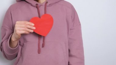 Dans eden ve kırmızı bir kalbe sarılan bir kadın. Sevgililer Günü, Uluslararası Kadınlar Günü ya da Anneler Günü için moda video afişi