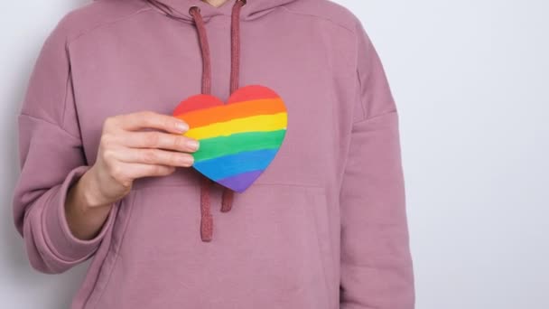 Kobieta lub dziewczyna w fioletowej bluzie z kapturem gospodarstwa ciepła malowane w kolorach Gay Pride Flag Kolorowy symbol LGBTQIA rozdzielczości 4K baner wideo. — Wideo stockowe