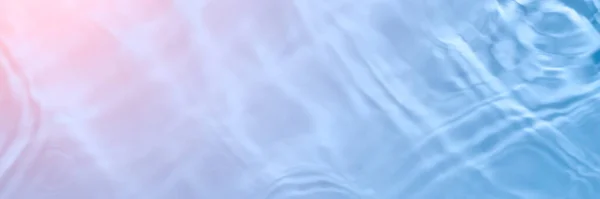 Sérum ou texture de l'eau en gros plan. Fond gel liquide dégradé bleu clair et rose. Échantillon transparent de soins de beauté. Cosmétique clair crème liquide tache. Longue bannière avec espace de copie. — Photo