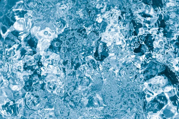 Blue Pool or hot tub water background close up. Ripples on blue transparent water in swimming pool with light reflection. Top view. Summer banner — стоковое фото