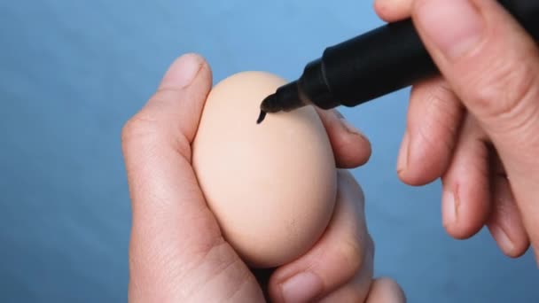 Çiftçi eli yumurtaya gülen surat çiziyor. Yaratıcı Paskalya konsepti. Paskalya 'nın kültürel sembolü. Çizilmiş yüzlü organik çiftlik yumurtaları.. — Stok video
