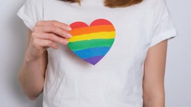 LGBTQIA 4K çözünürlüklü video pankartın renkli renkleriyle boyanmış beyaz tişörtlü kadın ya da kız.