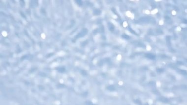 Su dokusuna yakın görünüm ve su üzerindeki dalgalar mavi tonlu video modelleme efekti. Organik ışık, ışığın dalga kırılma etkisiyle gölge düşürür. Yavaş çekim video pankartı.