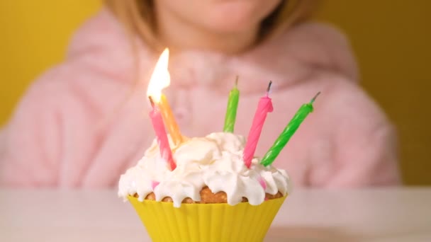 ピンクの幸せな子供の女の子全体がパーティーで誕生日ケーキに5本のろうそくを吹き消します 女の子の顔を閉じてください スローモーション幸せな誕生日ビデオバナー — ストック動画