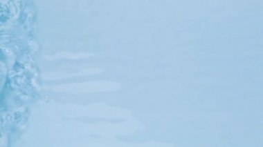 Su dokusunu, su damlaları ile kaplama efektiyle, video modellemesi için kapatın. Işığın dalga kırılması ile birlikte organik mavi gölge yakıcı etkisi. 4K çözünürlük video pankartı