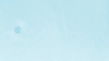 Su dokusunu, su damlaları ile kaplama efektiyle, video modellemesi için kapatın. Işığın dalga kırılması ile birlikte organik mavi gölge yakıcı etkisi. Yavaş çekim video pankartı