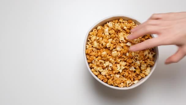 Top View Hand Greedily Takes Popcorn Paper Bucket Isolated White — ストック動画