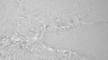 Transparent clear calm water surface texture with waves, splashes and bubbles. Trendy abstract nature background. White grey water waves in sunlight. Slow motion Full HD video banner.