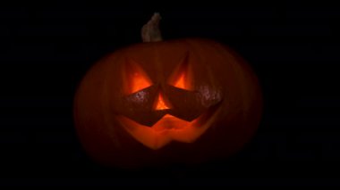 Funny and Scary Halloween pumpkin with a candle inside isolated on black background. Scary smiling Halloween pumpkin DIY concept. Jack-o-lantern.