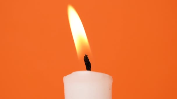 Eine Weiße Kerze Brennt Auf Einem Leuchtend Orangefarbenen Hintergrund Eine — Stockvideo