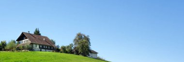 Zofingen, İsviçre - 19.09.2022: Zofingen, İsviçre 'nin banliyölerinde geniş bir çayırı olan bir tepede güzel eski bir çiftlik evi