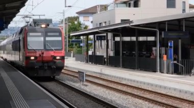 Zofingen, İsviçre - 19.09.2022: tren istasyonu, binalar, bir trenin gelişi ve İsviçre 'nin Zofingen kentindeki yolcular. 4K çözünürlük videosu
