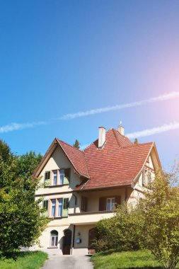 Zofingen, İsviçre - 19.09.2022: İsviçre 'nin Zofingen banliyösündeki ağaçların arasındaki yamaçta güzel eski bir ev