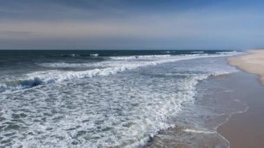 Atlantik Okyanusu 'nun boş sahillerindeki yüksek dalgaların güzel manzarası. Terk edilmiş güzel bir okyanus plajı. Tam HD yavaş çekim deniz video pankartı.