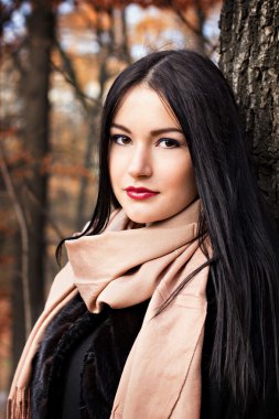 Güz parkında güzel genç bir kadın.