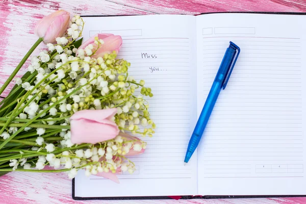 Notebook, inscription "miss you" and a bouquet of lilies and tul — Stock Photo, Image