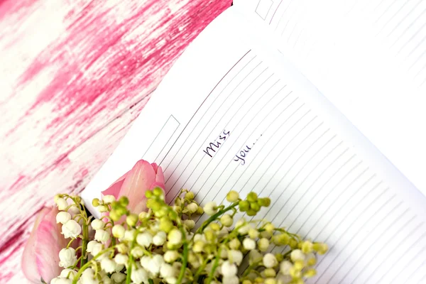 Entry in the diary "Miss you" and lily of the valley and pink tu — Stock Photo, Image