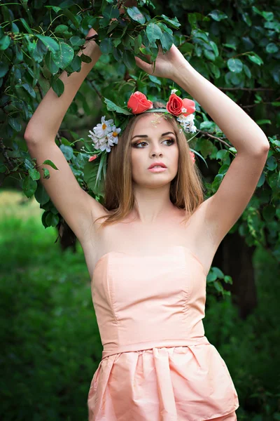 Beautiful young woman with a wreath of flowers on her head — Stock Photo, Image