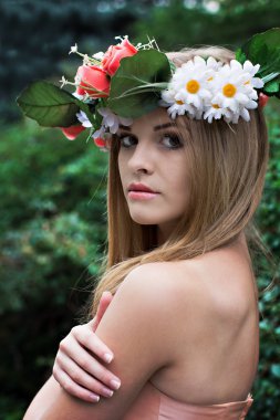 başında çiçek çelenk ile güzel bir genç kadın