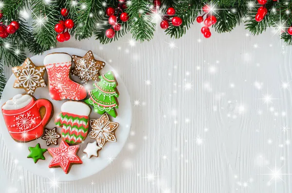 Χριστουγεννιάτικα σπιτικά μπισκότα μελόψωμου και κλαδιά ελάτης σε λευκό ξύλινο φόντο. — Φωτογραφία Αρχείου
