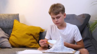 Öğrenci, kağıt hamuru dağı şeklinde yaratıcı bir proje yapıyor..