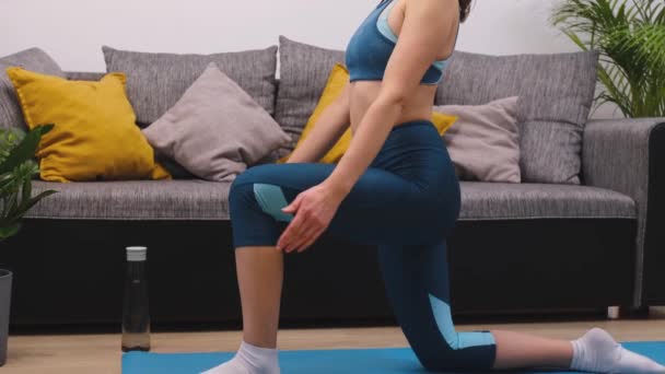 Schöne junge Frau macht Fitnesstraining, hebt die Hände und beugt sich — Stockvideo