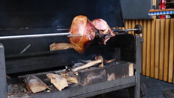 프라하의 야외 불에서맛있는 돼지고기 햄 요리를 하고 있습니다. 침에 구운 돼지고기. — 비디오