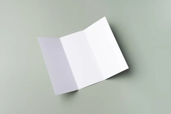 Biała makieta białej, potrójnej broszury na jasnozielonym tle. Makieta karty. — Zdjęcie stockowe