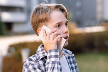 Şehir ortamında telefonla konuşan bir gencin yakın plan portresi..