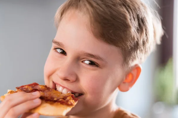 Szczęśliwy nastolatek cieszy się jedząc pyszną pizzę w domu. Portret uroczej nastolatki — Zdjęcie stockowe