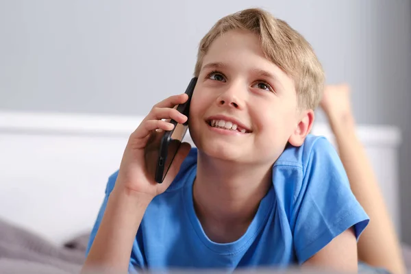 Portret Uroczego Chłopca Rozmawiającego Przez Telefon Leżącego Łóżku Domu Bezprzewodowa — Zdjęcie stockowe
