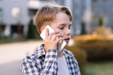 Akıllı telefondan konuşan modern bir gencin yakın plan portresi. Şehirdeki gençlik hayatı. Yeni nesil