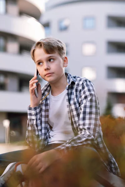 Nastoletni Chłopak Rozmawia Przez Telefon Miejskim Środowisku Siedząc Ławce Styl — Zdjęcie stockowe